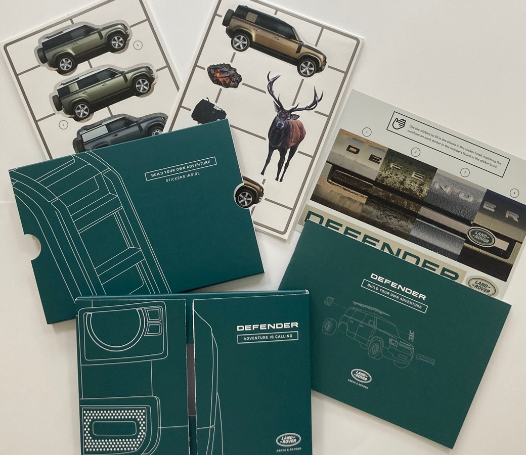 Land Rover Defender promotional kit with sticker books and adventure-themed inserts